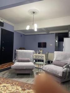 ein Wohnzimmer mit 2 Stühlen und einem Tisch in der Unterkunft İstanbul’un Merkezi in Istanbul