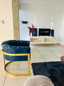 a blue chair in a living room with a tv at Sky View Escape in Windhoek