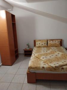 コスティネシュティにあるVila La Foisorのベッドルーム1室(ベッド1台付)、木製キャビネットが備わります。