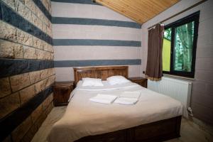 a bedroom with a bed with two towels on it at Arevik Resort Cottages in Sevan
