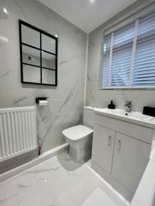 a white bathroom with a toilet and a sink at Coastal Apartments No 1 in Seaham