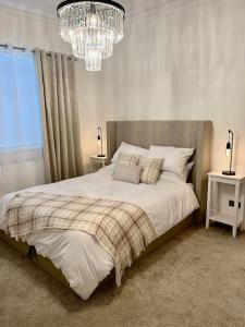 a bedroom with a large bed and a chandelier at Coastal Apartments No 1 in Seaham