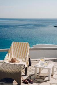 een stoel en een tafel met een handdoek en een tafel met bij Maison Simone with private heated infinity pool & spectacular sea view in Agios Sostis