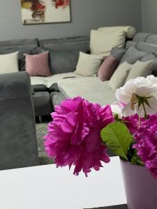 ein Wohnzimmer mit lila und weißen Blumen auf dem Tisch in der Unterkunft Villa Dalia in Sarajevo