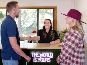 a man and a woman shaking hands at a counter at Sierra Blue Hotel & Swim Club in Big Bear Lake