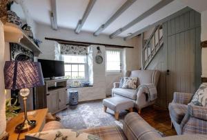 a living room with a couch and chairs and a television at Escape to Ancarva Cottage near Falmouth in Perranwell