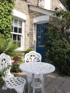 a table and two chairs in front of a house at Escape to Ancarva Cottage near Falmouth in Perranwell