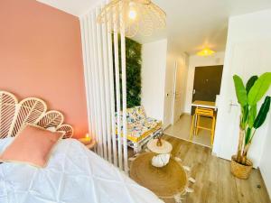 a bedroom with a bed and a chair and a table at LAKAZ CREOLE - Caen Centre in Caen