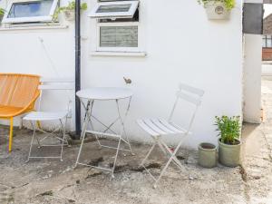 two chairs and a table in front of a white wall at The Epple Bay Retreat in Birchington