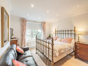 a bedroom with a bed and a couch at The Cottage in St Margarets at Cliff