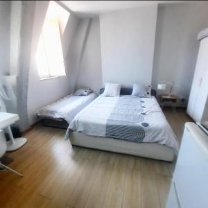 - une chambre avec 2 lits et une fenêtre dans l'établissement Studio Jean LEBELIN, à Dijon