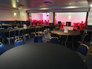 a room with tables and chairs and a large screen at Gilson Hotel in Hull