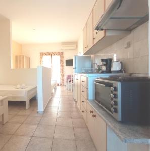 una cocina con electrodomésticos azules y una mesa en una habitación en Flower Apartments, en Gouves