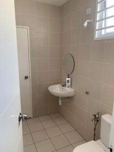 a bathroom with a sink and a mirror and a toilet at Ann Homestay Laman Sendayan in Kampong Baharu Jimah