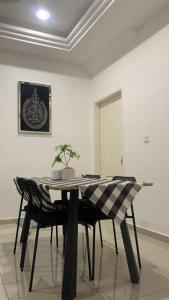 a dining room table with chairs in a room at Ann Homestay Laman Sendayan in Kampong Baharu Jimah