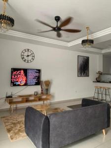 sala de estar con sofá y reloj en la pared en Ann Homestay Laman Sendayan, en Kampong Baharu Jimah