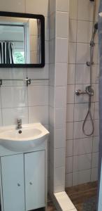 a bathroom with a sink and a shower with a mirror at NASZE 4 KĄTY in Junoszyno