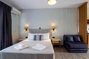 ein Hotelzimmer mit einem Bett und einem blauen Stuhl in der Unterkunft Thea comfy living in Nea Vrasna