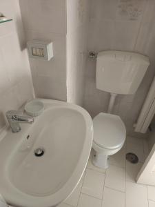 uma casa de banho branca com um WC e um lavatório em Maison Olimpo em Trani
