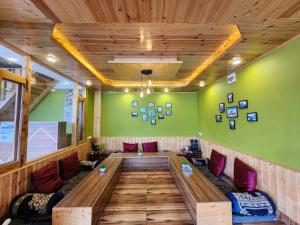 a large wooden table in a room with green walls at Timberwolves in Manāli