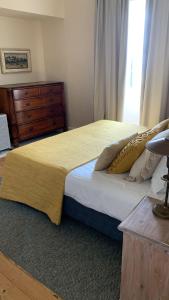 a bedroom with a bed with a dresser and a window at Quinta das Vinhas in Calheta