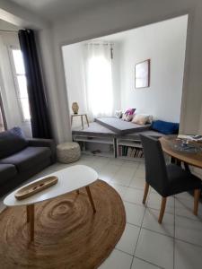 een woonkamer met een bank en een tafel bij Les catalans, vue mer in Marseille