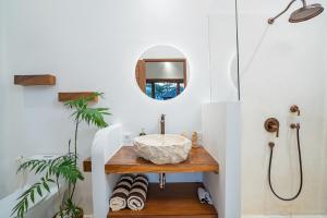 a bathroom with a sink and a mirror at EHOA BALI Nyanyi Boutique Hotel in Tanah Lot