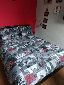 a bed with a black and white quilt on it at White Hart Lane walking distance Tottenham Hotspur Stadium in London