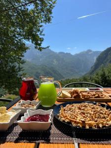 einen Tisch mit Speisen und Getränken auf einem Tisch in der Unterkunft Villa Davisol in Theth