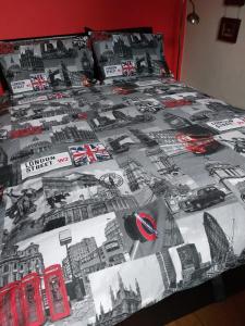 a bed with a black and white comforter on it at White Hart Lane walking distance Tottenham Hotspur Stadium in London