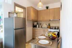 a kitchen with a stainless steel refrigerator and a table at Georgia Apartment in Matala