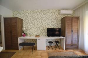 a room with a desk with a television and two chairs at Studio Matovic Vrnjacka Banja in Vrnjačka Banja