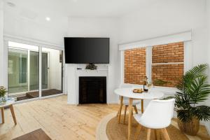 een woonkamer met een tafel en een open haard bij Eastern Beach Retreat in Geelong