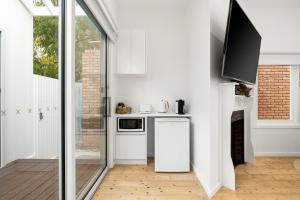 een keuken met witte apparatuur en een glazen schuifdeur bij Eastern Beach Retreat in Geelong