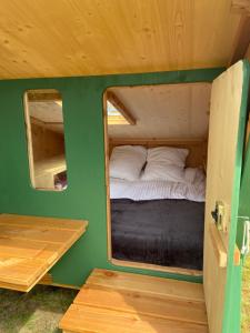 - une petite chambre avec un lit et un miroir dans l'établissement Cabane Etape, à Morlaix