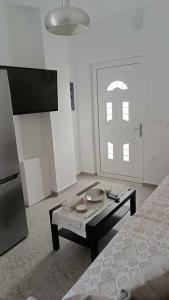 a room with a bed and a table and a door at Restaurant Maria Suites SunSet in Faliraki