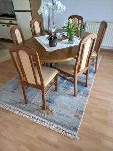 a wooden dining room table and chairs with a table and a rug at Apartman MN in Čapljina +5 photos