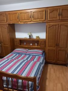 a bedroom with a bed with wooden cabinets at Apartman MN in Čapljina