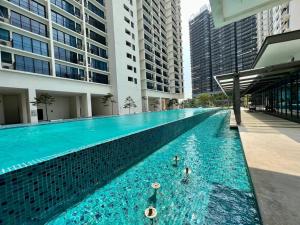 een groot zwembad in een stad met hoge gebouwen bij Sweet Home at Trefoil Setia Alam in Shah Alam