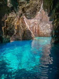 una piscina de agua azul en una cueva en Villa Ecclesiae, en Iglesias