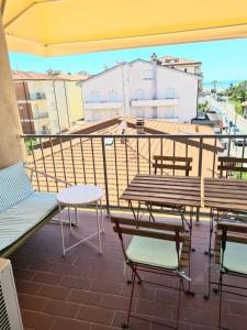 a balcony with benches and tables on a building at Hotel Perla Del Mare in Lido di Camaiore