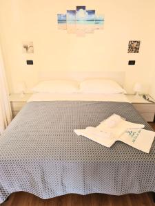 a bedroom with a bed with a blue and white bedspread at Hotel Perla Del Mare in Lido di Camaiore