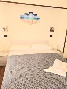 a bedroom with a bed with a blue and white bedspread at Hotel Perla Del Mare in Lido di Camaiore
