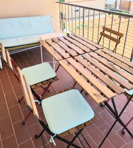a wooden bench and two chairs on a balcony at Hotel Perla Del Mare in Lido di Camaiore