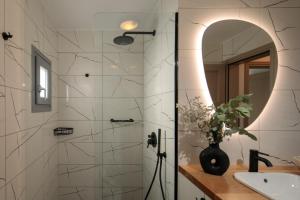 a bathroom with a shower with a sink and a mirror at Jannas Apartments Naxos in Naxos Chora