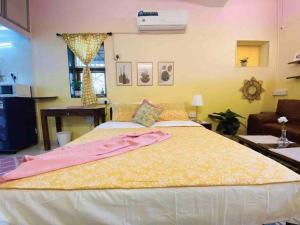 a bedroom with a large bed with a yellow blanket at Bandra Studio Lokhandwala House, Near Carter Road, Palli Hill by Connekt Homes in Mumbai
