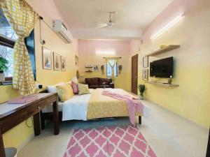 a bedroom with a bed and a couch and a television at Bandra Studio Lokhandwala House, Near Carter Road, Palli Hill by Connekt Homes in Mumbai
