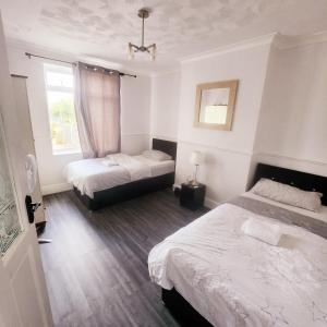 a bedroom with two beds and a window at The Comfy Resort, Free Private Parking & Wifi, 9 beds in Colchester
