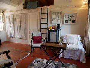 een woonkamer met 2 stoelen en een tafel bij La maison de Muriel in Rustrel