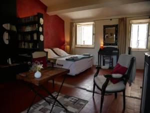 een slaapkamer met een bed, een bureau en een stoel bij La maison de Muriel in Rustrel